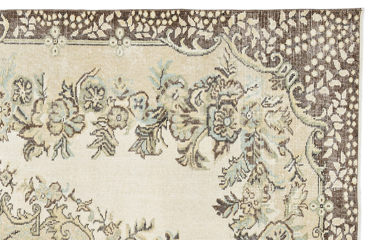 Cream, brown, and light blue traditional rug with a floral medallion pattern and a wide decorative border.