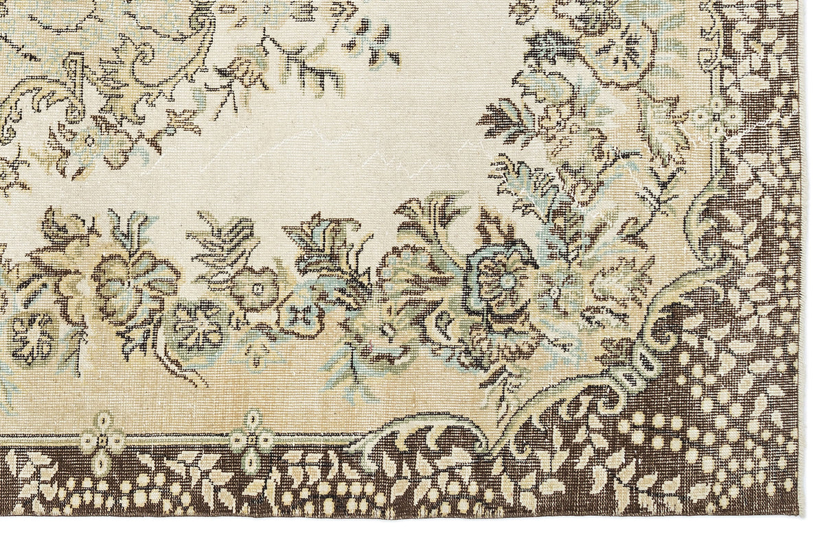 Cream, brown, and sage green traditional rug with a floral medallion pattern and a dark brown border.