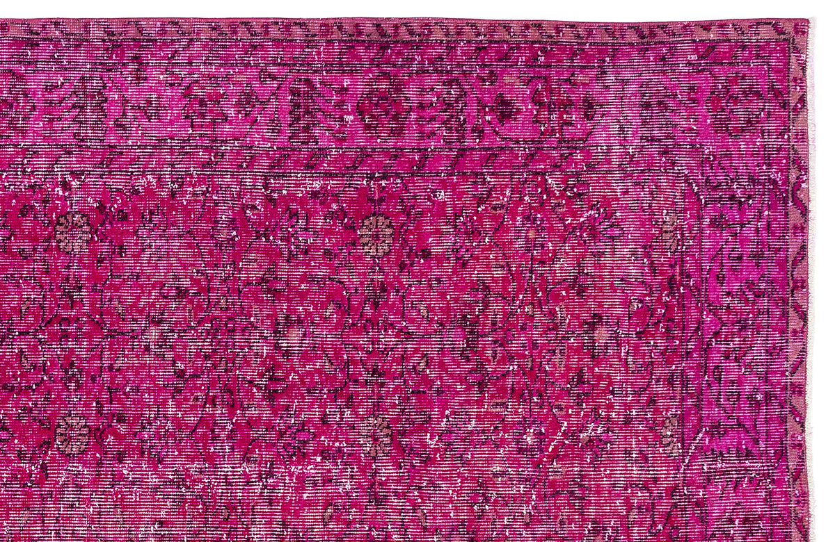 Magenta distressed rug with a traditional floral medallion pattern and a dark border.