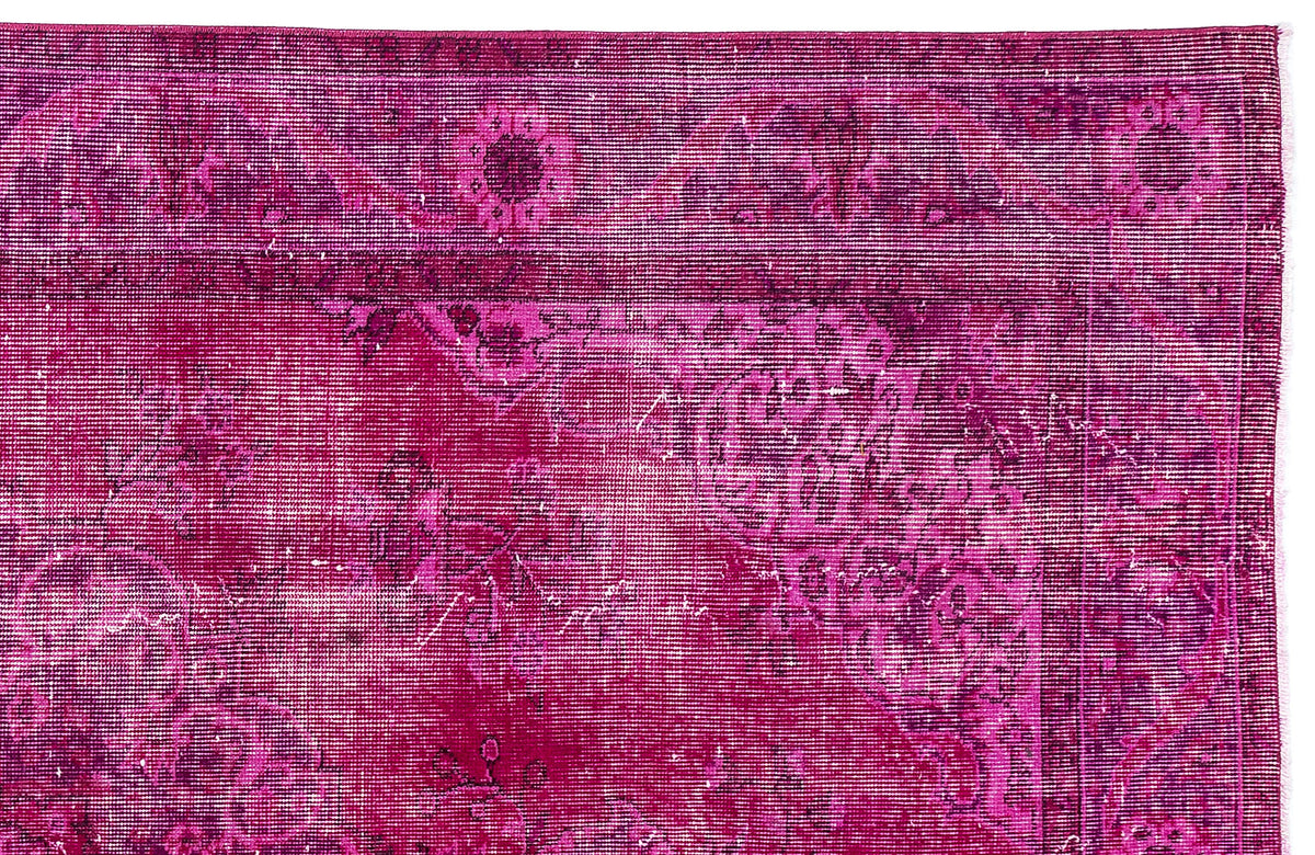 Magenta distressed rug with a traditional floral medallion pattern and a bordered edge.