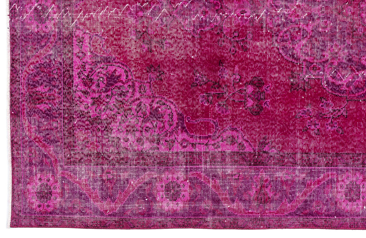 Magenta distressed rug with a traditional floral medallion pattern and a wide decorative border.