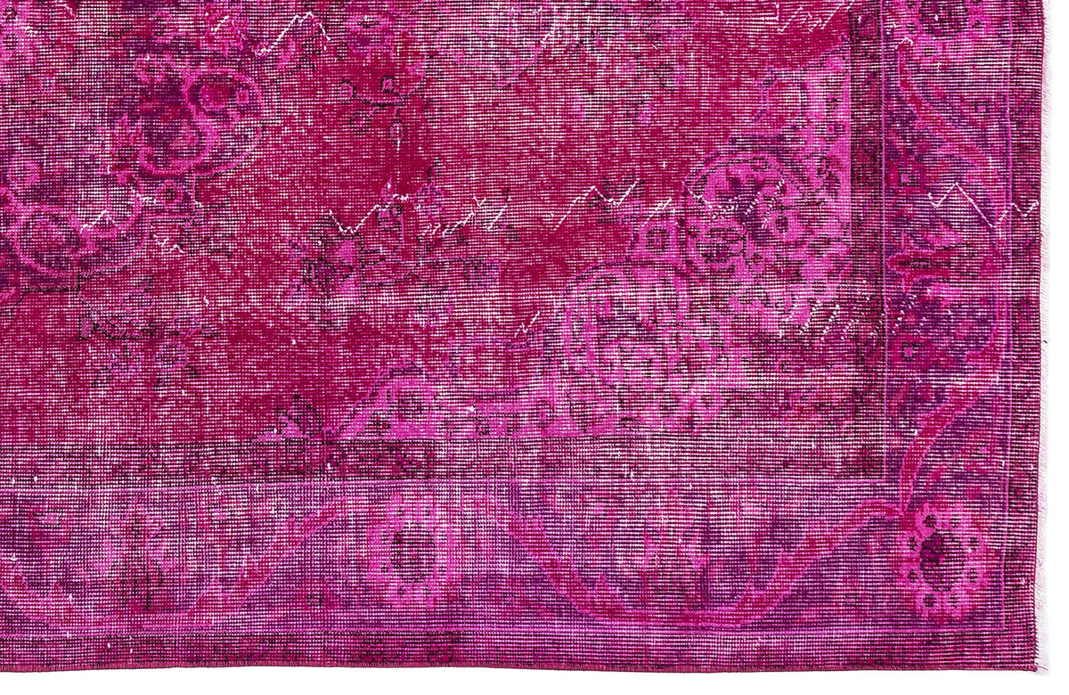 Magenta and deep purple distressed rug with a faded traditional floral medallion pattern.