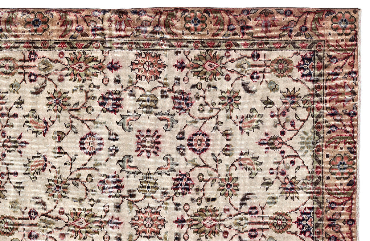 Beige traditional rug with a floral vine pattern in muted red, green, and navy blue, featuring a decorative border.