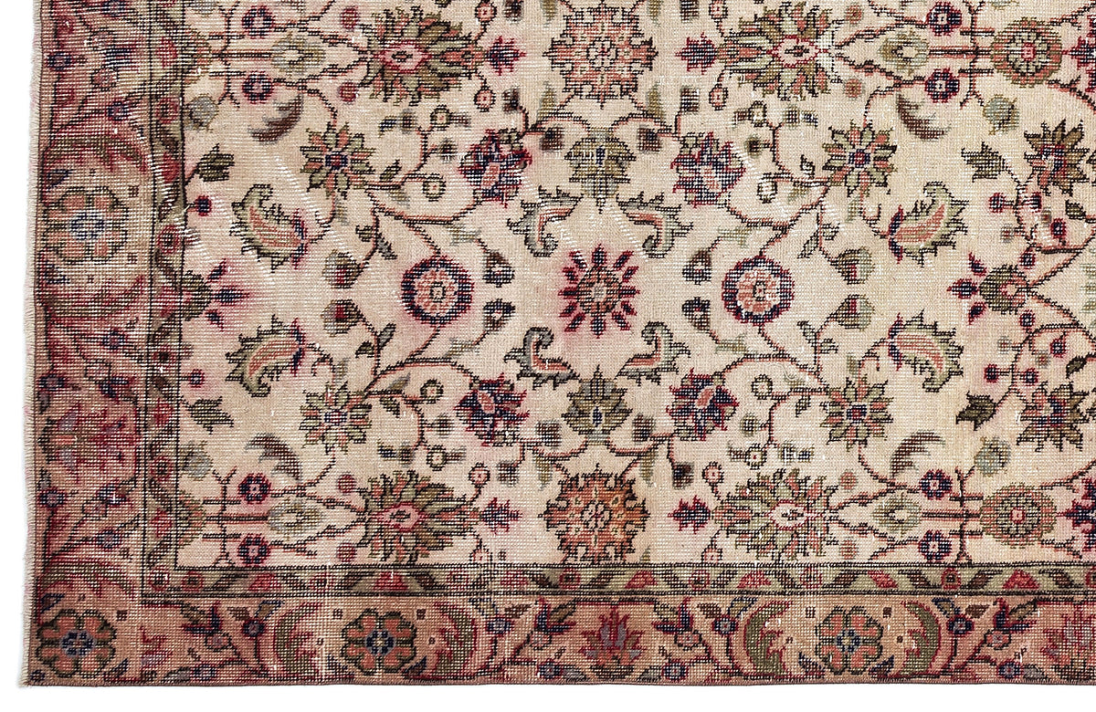 Beige traditional rug with a multi-colored floral vine pattern and a detailed decorative border.