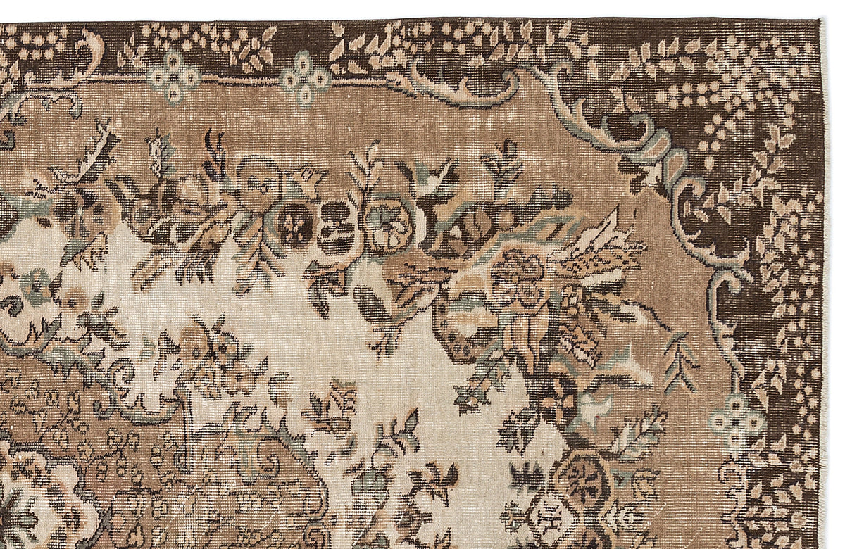Distressed brown and beige rug with a traditional floral medallion pattern and muted teal accents.