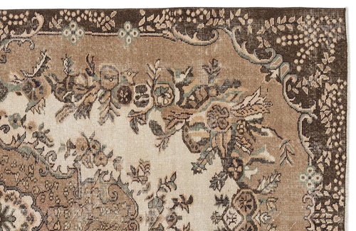 Load image 1 in gallery view. Distressed brown and beige rug with a traditional floral medallion pattern and muted teal accents.