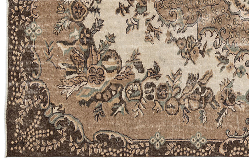 Load image 1 in gallery view. Distressed brown and cream rug with a traditional floral medallion pattern and muted teal accents.