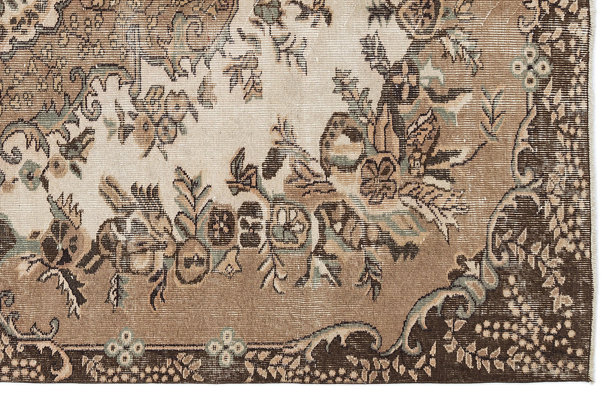 Distressed brown, beige, and sage green rug with a traditional floral medallion pattern.