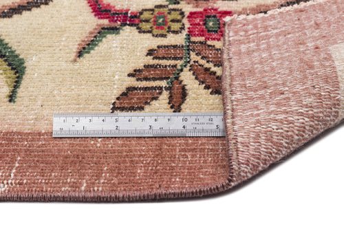 Load image 1 in gallery view. Beige vintage rug with floral patterns in red, brown, and green, shown with a metal ruler for scale.