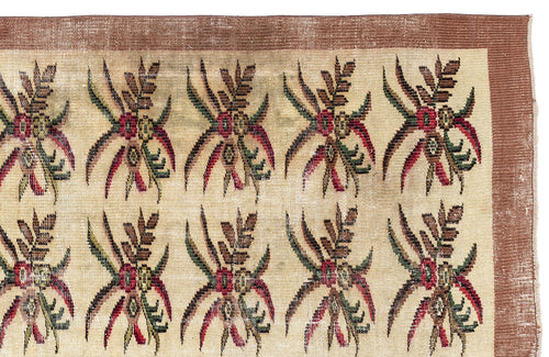Load image 1 in gallery view. Beige rug with a repeating floral motif in red, green, and brown, featuring a wide brown border.