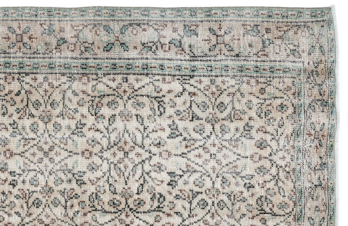 Beige and sage green traditional rug with a distressed floral pattern and a decorative border.