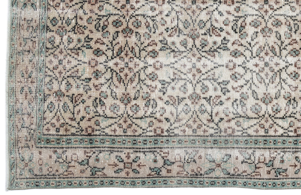 Beige and teal traditional rug with a distressed floral medallion pattern and a decorative border.