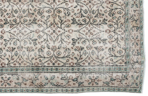 Load image 1 in gallery view. Beige vintage-style rug with a distressed floral pattern in muted teal and brown, featuring a decorative border.