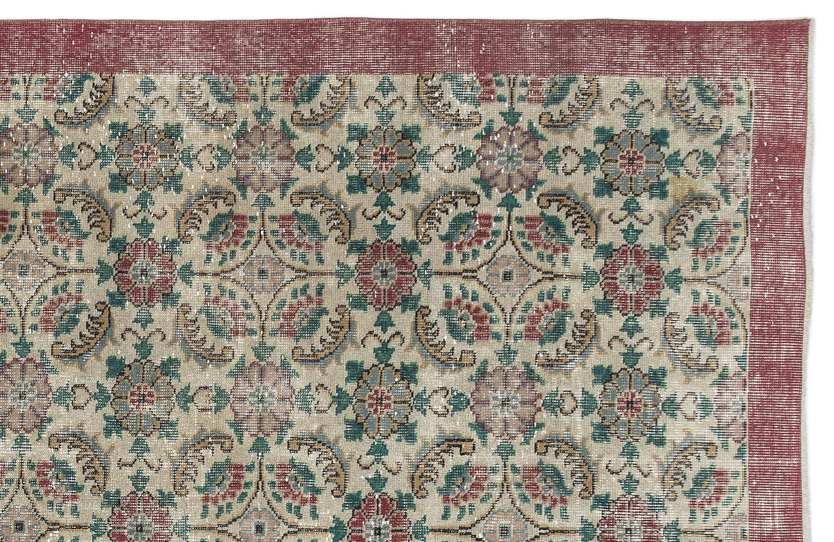 Beige vintage-style rug with a red border and a repeating floral medallion pattern in red, green, and blue.