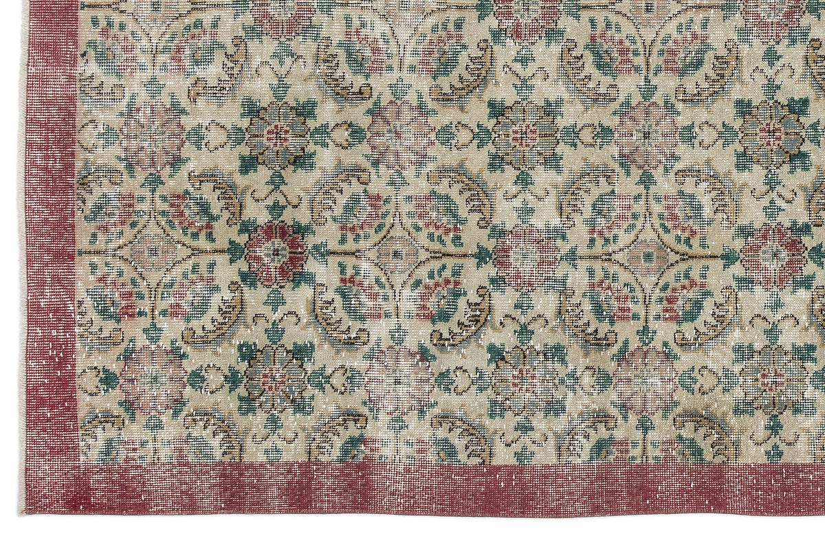 Beige rug with a distressed floral medallion pattern in red, green, and blue, featuring a solid red border.