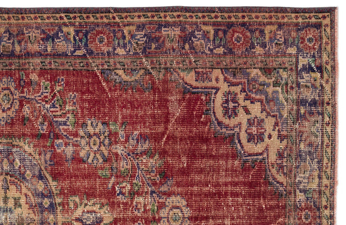 Load image 1 in gallery view. Distressed red rug with a blue and beige floral medallion pattern and a decorative border.