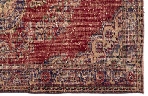 Load image 1 in gallery view. Distressed red rug with a beige and blue floral medallion pattern and a detailed geometric border.