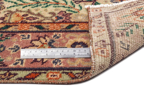 Load image 1 in gallery view. Multi-colored floral patterned rug with a folded corner and a metal ruler for scale on a white background.