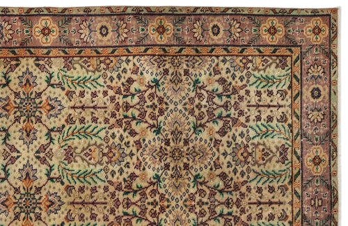 Load image 1 in gallery view. Traditional Persian-style rug with a beige field, intricate floral motifs, and a mauve border with repeating medallions.