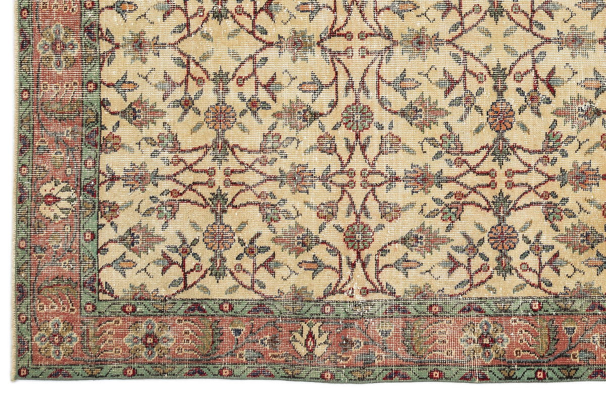 Beige rug with a traditional floral vine pattern in red, green, and blue, featuring a decorative multi-colored border.