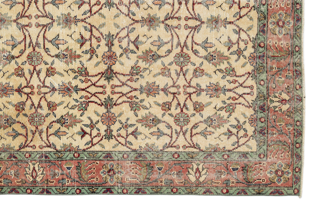 Beige rug with a traditional floral vine pattern in red, green, and blue, featuring a decorative border.