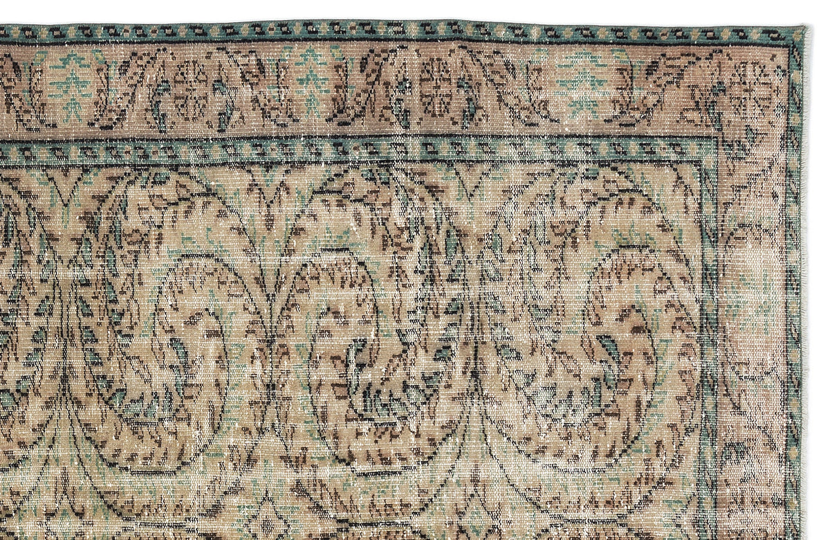 Distressed beige rug with a teal and brown traditional floral paisley pattern and a decorative border.