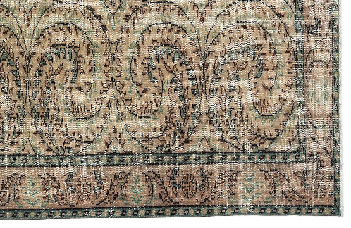 Distressed beige and teal rug with a traditional paisley and floral medallion pattern and a geometric border.