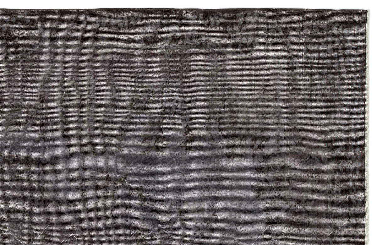 Dark charcoal and grey distressed rug with a faded traditional floral medallion pattern.