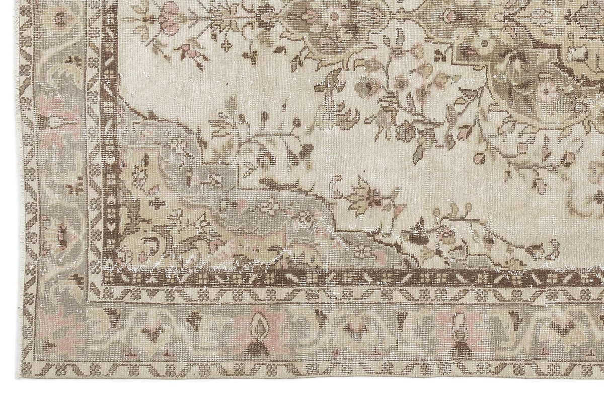 Distressed beige and brown traditional rug with a faded floral medallion pattern and intricate geometric border.