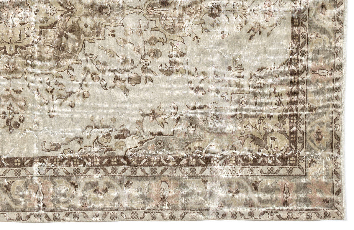 Distressed beige and brown traditional rug with a faded floral medallion pattern and a detailed geometric border.