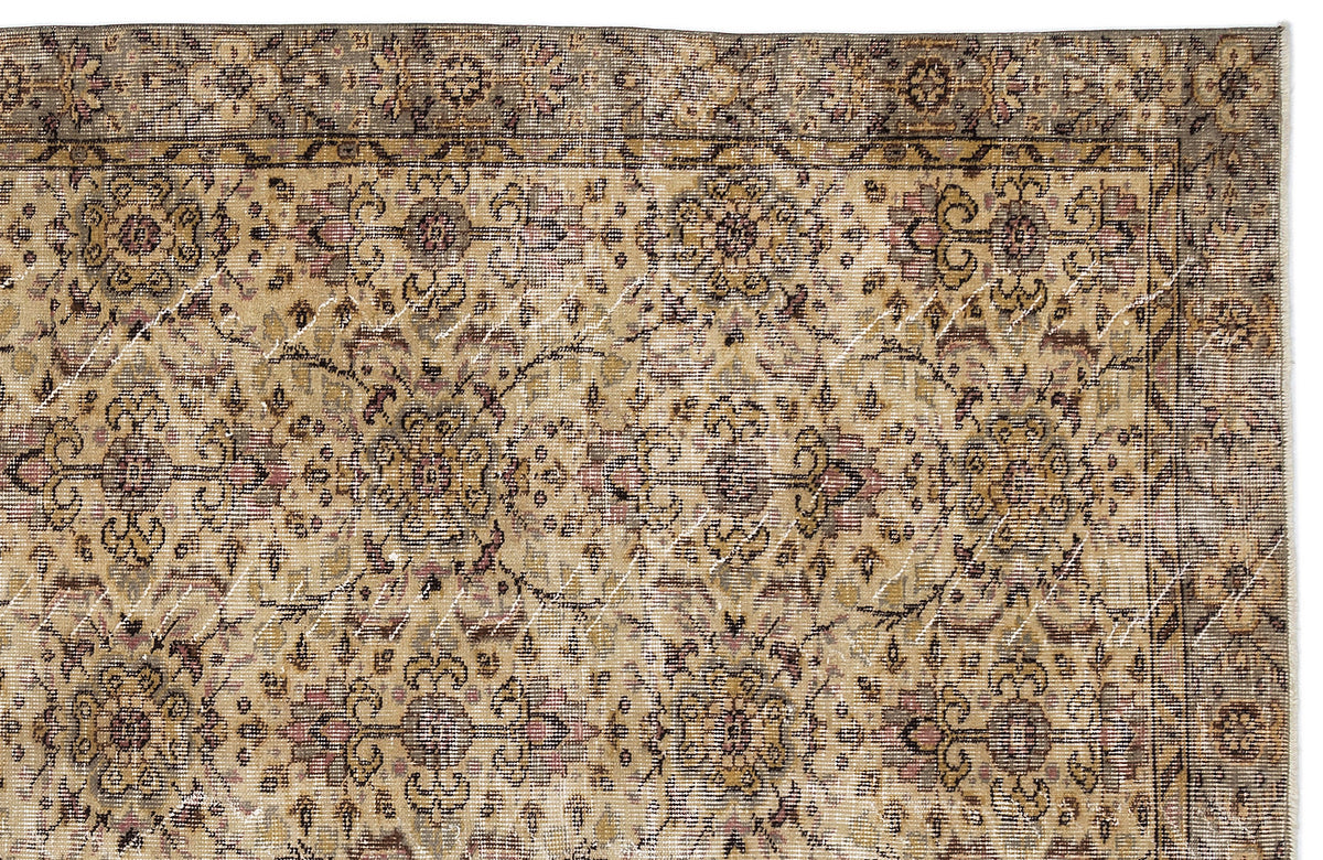 Distressed beige and brown rug with a traditional floral medallion pattern and a dark decorative border.