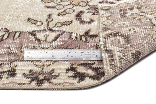 Load image 1 in gallery view. Distressed beige and mauve vintage-style rug with a floral medallion pattern, shown with a metal ruler for scale.