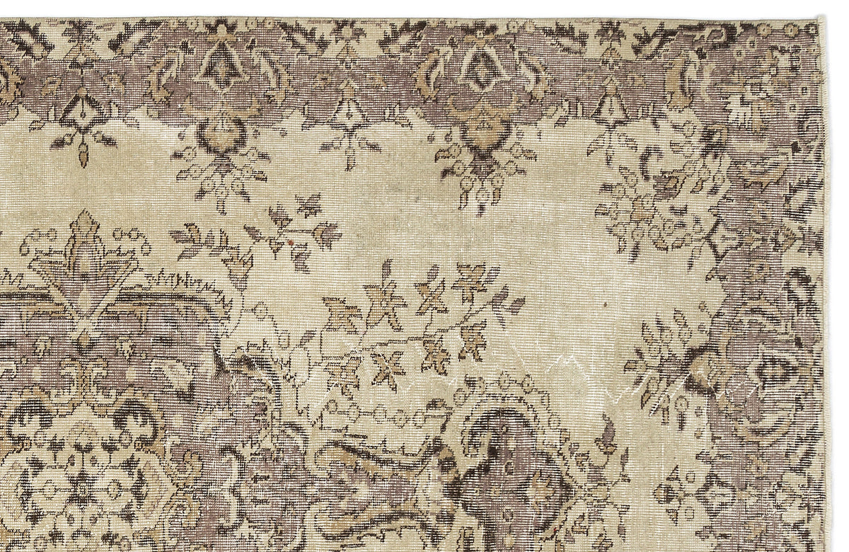 Distressed beige and taupe rug with a traditional floral medallion pattern and ornate border.