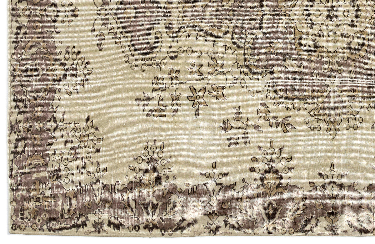 Beige and taupe rug with a distressed traditional floral medallion pattern and ornate border.