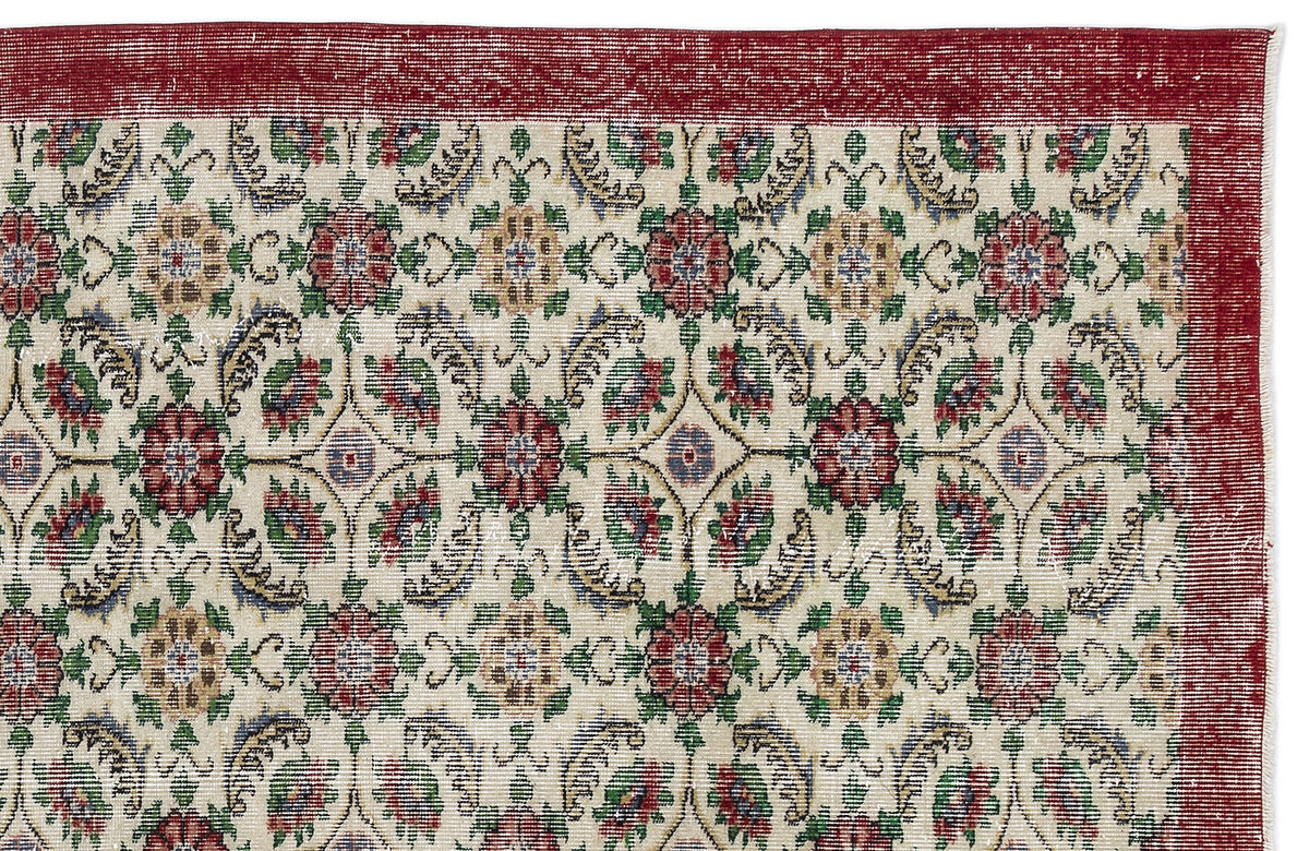 Cream rug with a red border and a repeating floral medallion pattern in red, green, and gold.
