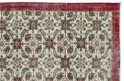 Load image 1 in gallery view. Cream rug with a red border and a repeating floral medallion pattern in red, green, and gold.