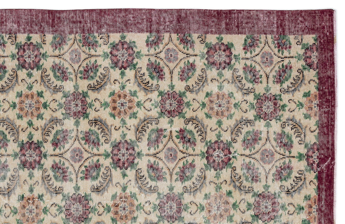 Beige rug with a repeating floral medallion pattern in burgundy, green, and tan, featuring a wide burgundy border.