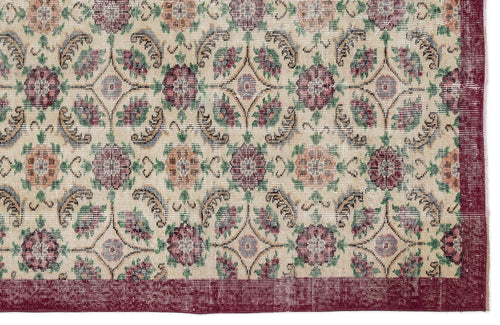 Load image 1 in gallery view. Beige rug with a repeating floral medallion pattern in burgundy, green, and blue, featuring a solid burgundy border.