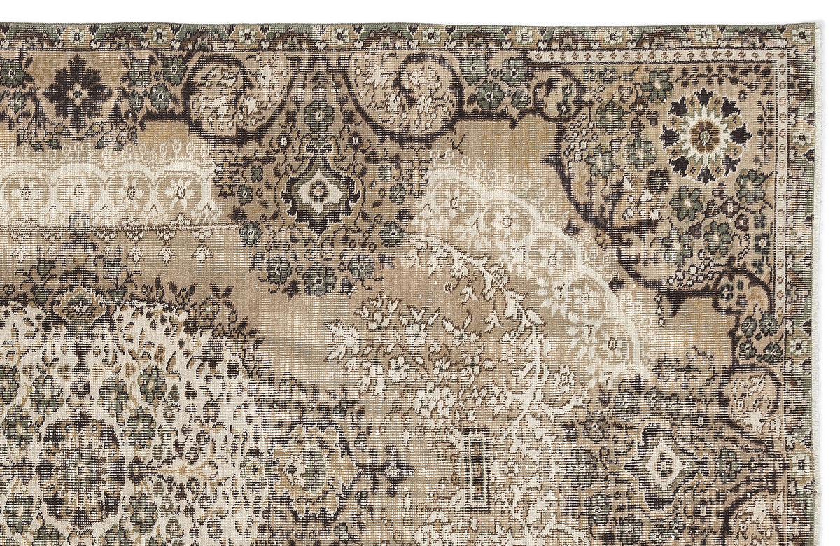 Tan, brown, and sage green traditional rug with a distressed, faded floral medallion pattern.