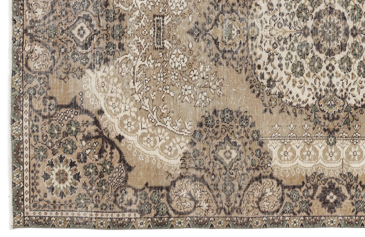 Distressed beige, brown, and sage green rug featuring a traditional floral medallion pattern with a faded finish.