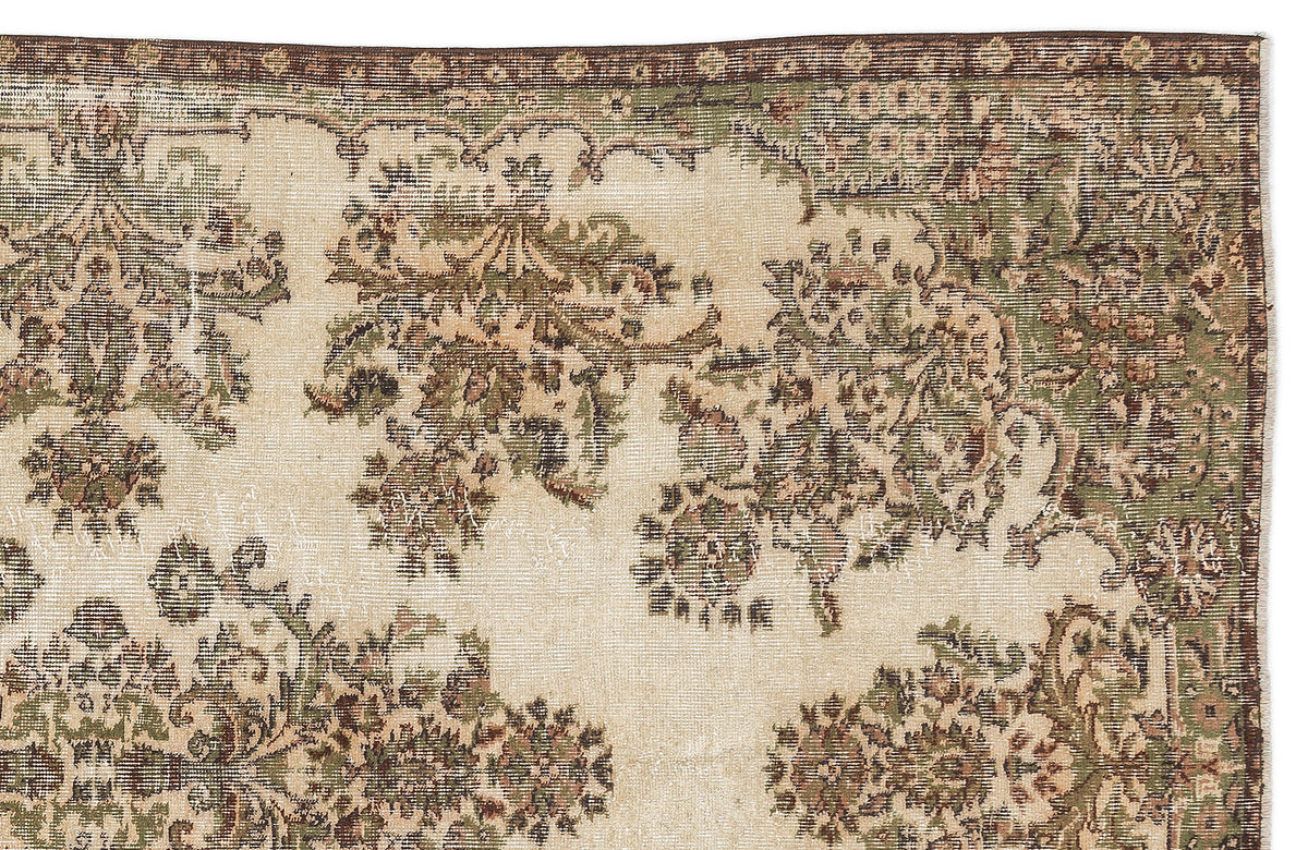 Beige rug with a distressed floral medallion pattern in olive green and brown, featuring a dark brown border.
