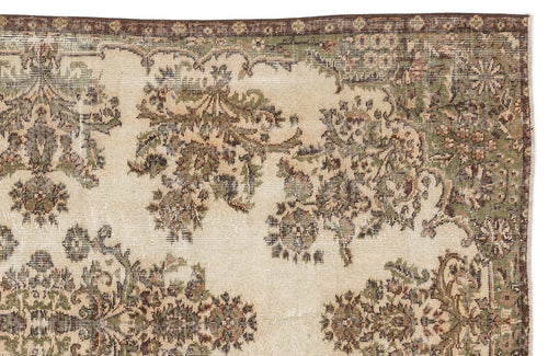 Load image 1 in gallery view. Beige rug with a distressed floral medallion pattern in olive green and brown, featuring a dark brown border.