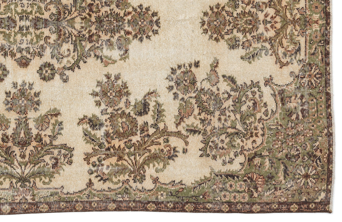 Beige rug with a distressed floral medallion pattern in olive green and brown, featuring a dark border.