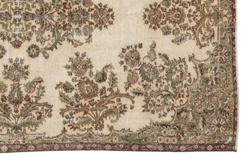 Load image 1 in gallery view. Beige rug with a distressed floral medallion pattern in olive green and brown, featuring a dark border.