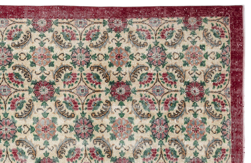 Load image 1 in gallery view. Beige rug with a red border and a repeating floral medallion pattern in red, green, and blue on a white background.
