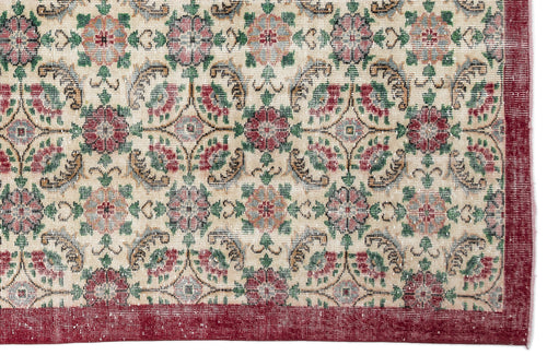 Load image 1 in gallery view. Beige rug with a repeating floral medallion pattern in red, green, and blue, featuring a solid red border.