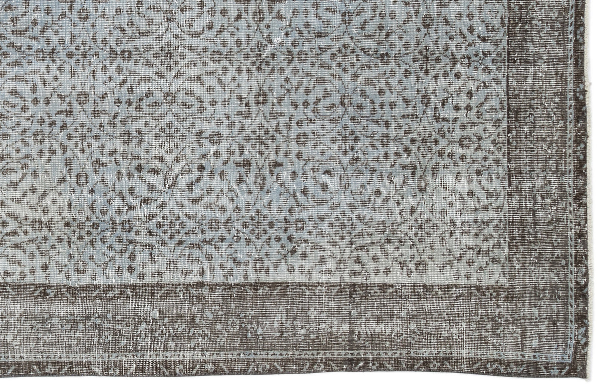 Light blue and charcoal grey rug with a distressed, intricate floral medallion pattern and a wide solid border.