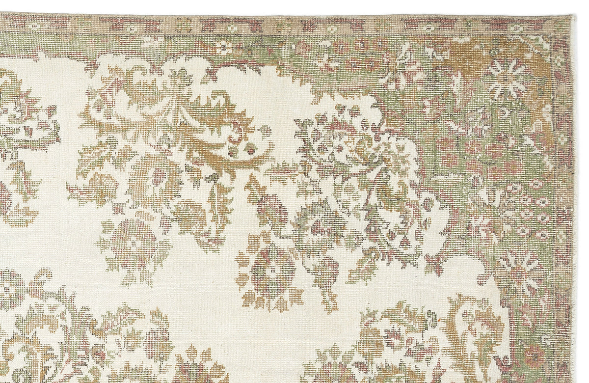 The Bofaya Vintage Medallion Rug (6'4" x 10'2") features a faded floral and vine pattern in muted green, beige, and pink on an ivory background, finished with an intricate patterned border.