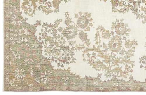 Load image 1 in gallery view. A close-up of the Bofaya - Vintage Medallion Rug (6'4" x 10'2") highlights its ornate floral pattern in muted green, beige, and brown tones, complete with a decorative border.