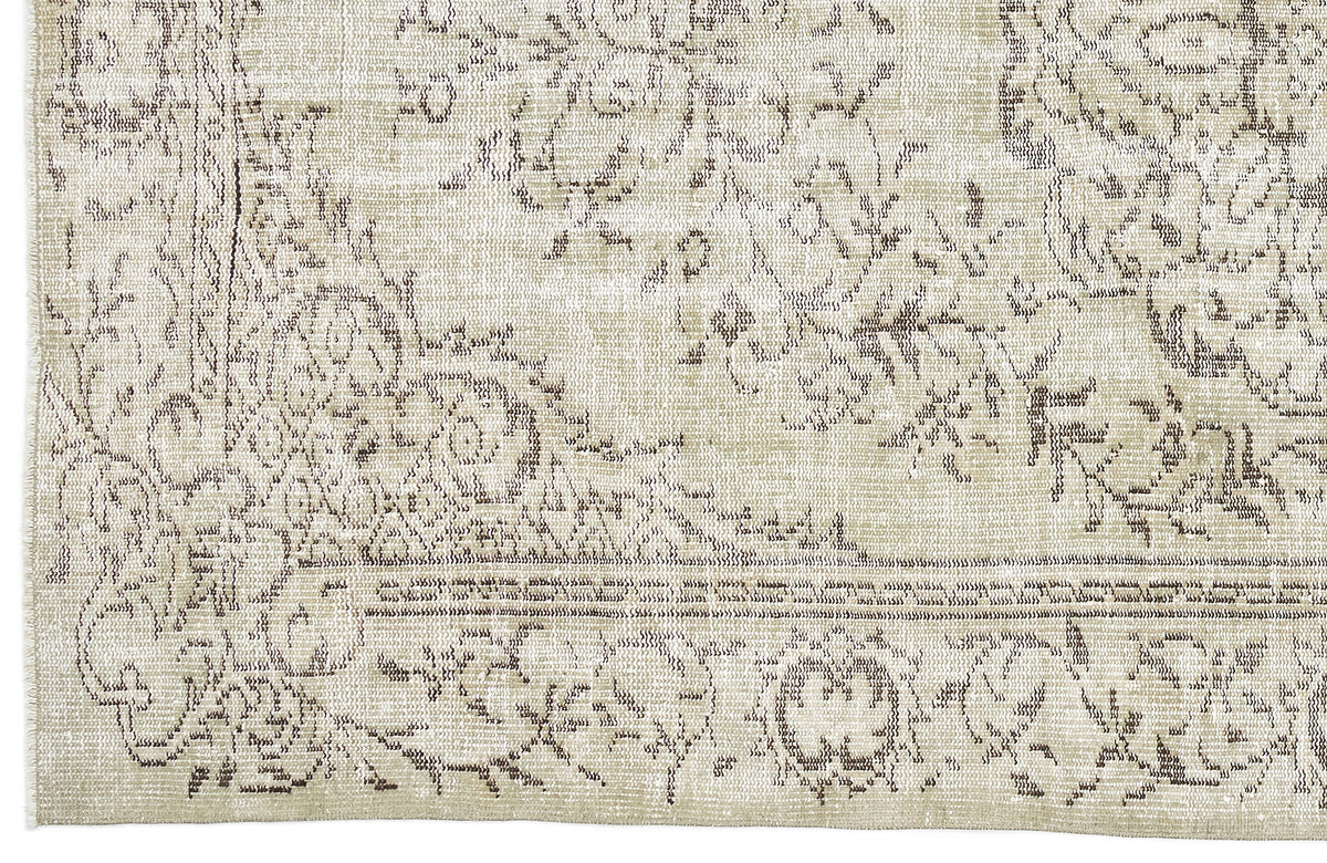 Beige and taupe vintage-style rug with a distressed, faded floral medallion pattern and a decorative border.